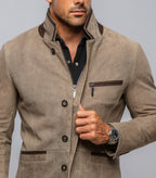 Man wearing a brown suede jacket with a gray background